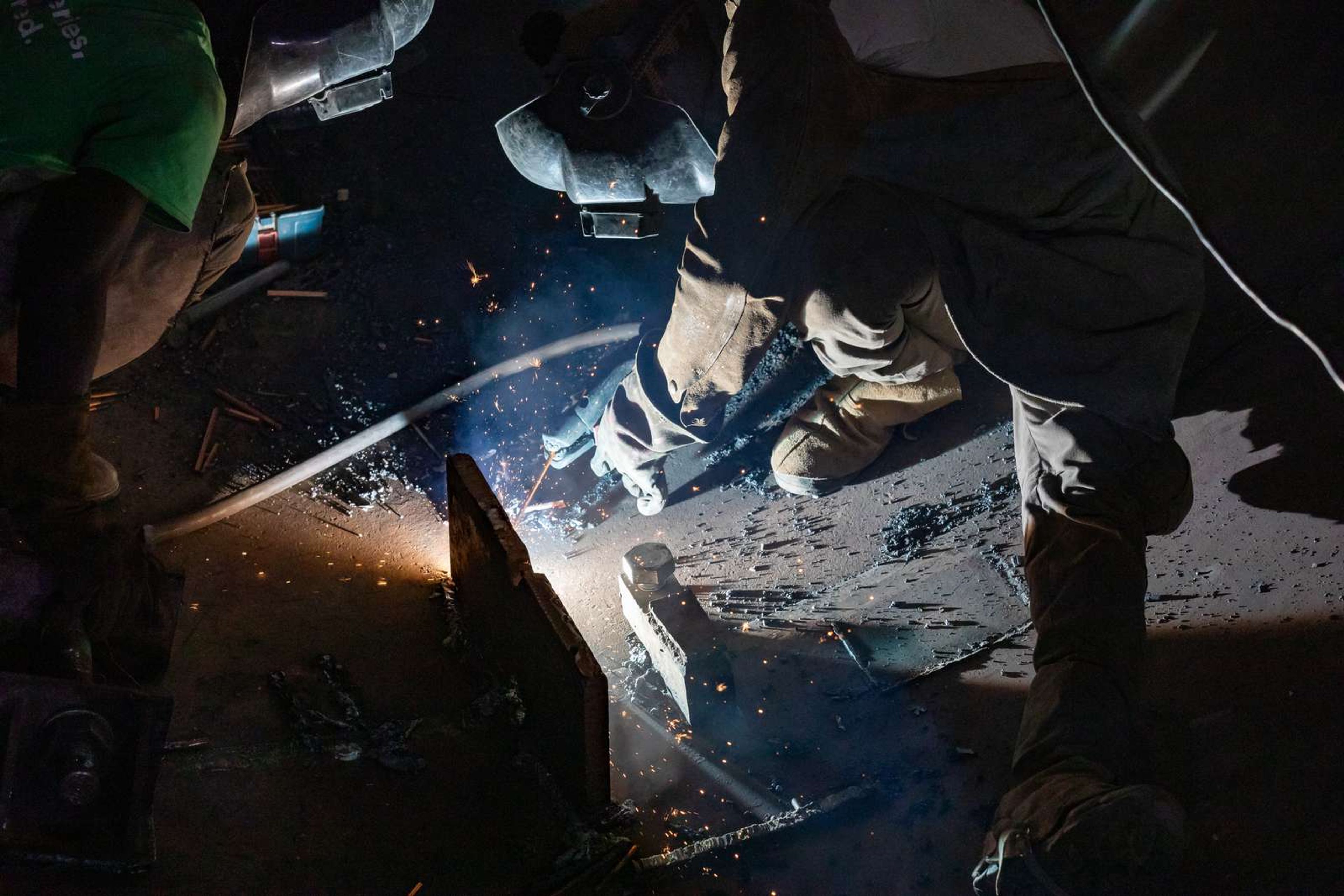 Industrial welding work during cement plant maintenance with sparks and safety equipment