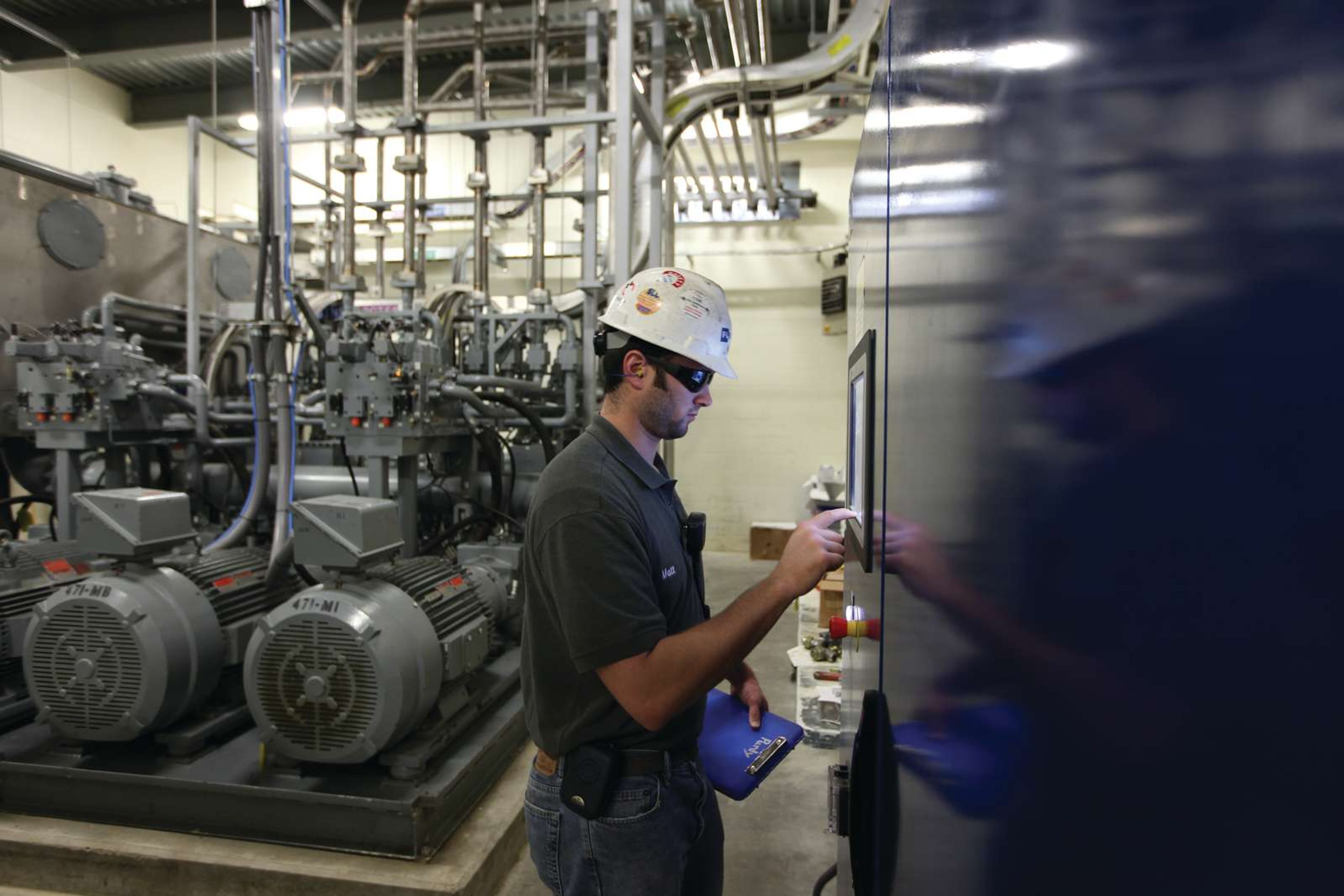 Engineer performing system check on pneumatic conveying equipment powering automated material transport