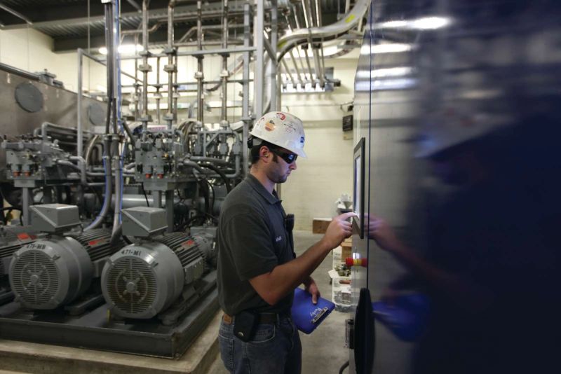 Engineer performing system check on pneumatic conveying equipment powering automated material transport