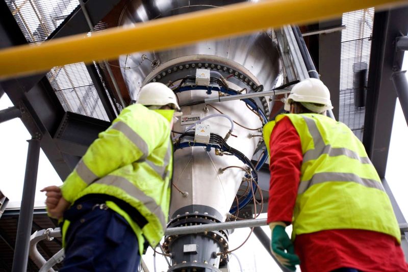 Engineers examining high-precision Pfister feeder system for consistent fuel dosing in cement production