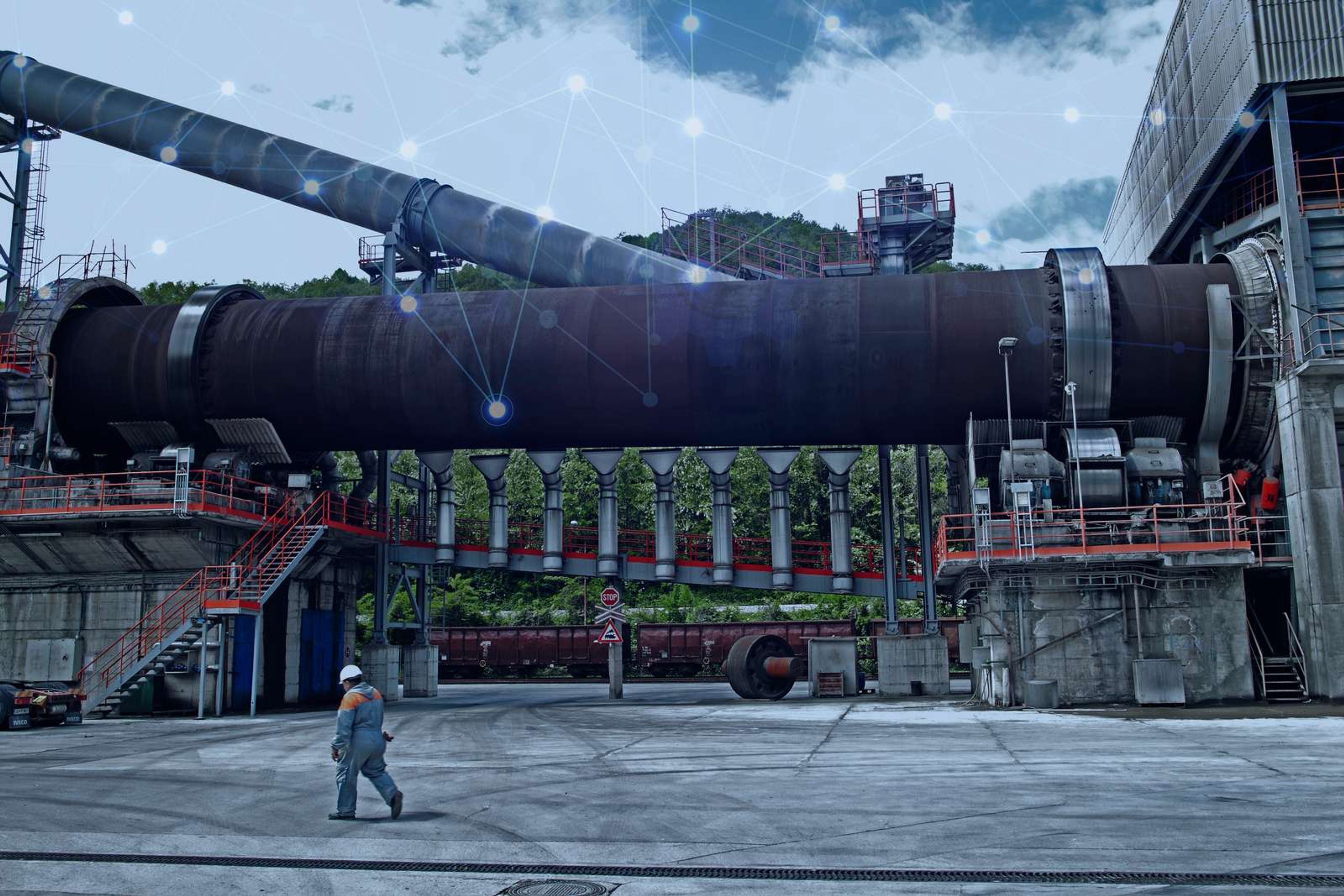 Cement plant rotary kiln with digital connectivity overlay representing smart process optimization
