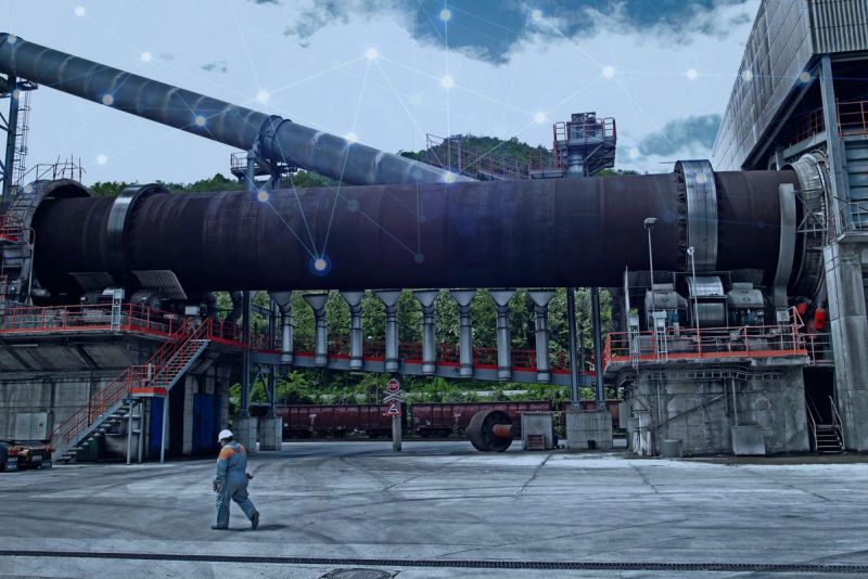 Cement plant rotary kiln with digital connectivity overlay representing smart process optimization